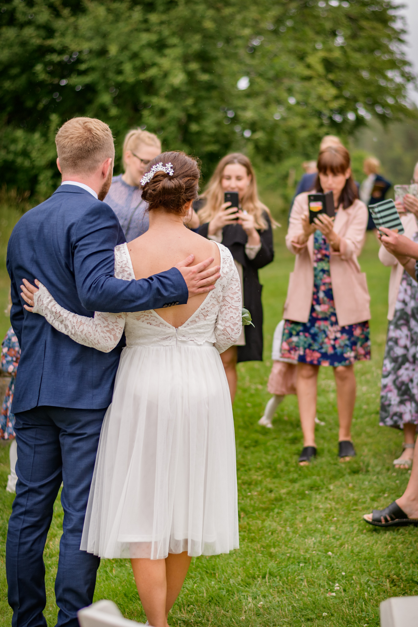 Bröllopsgäster fotograferar brudpar efter mobilfri vigsel, unplugged wedding